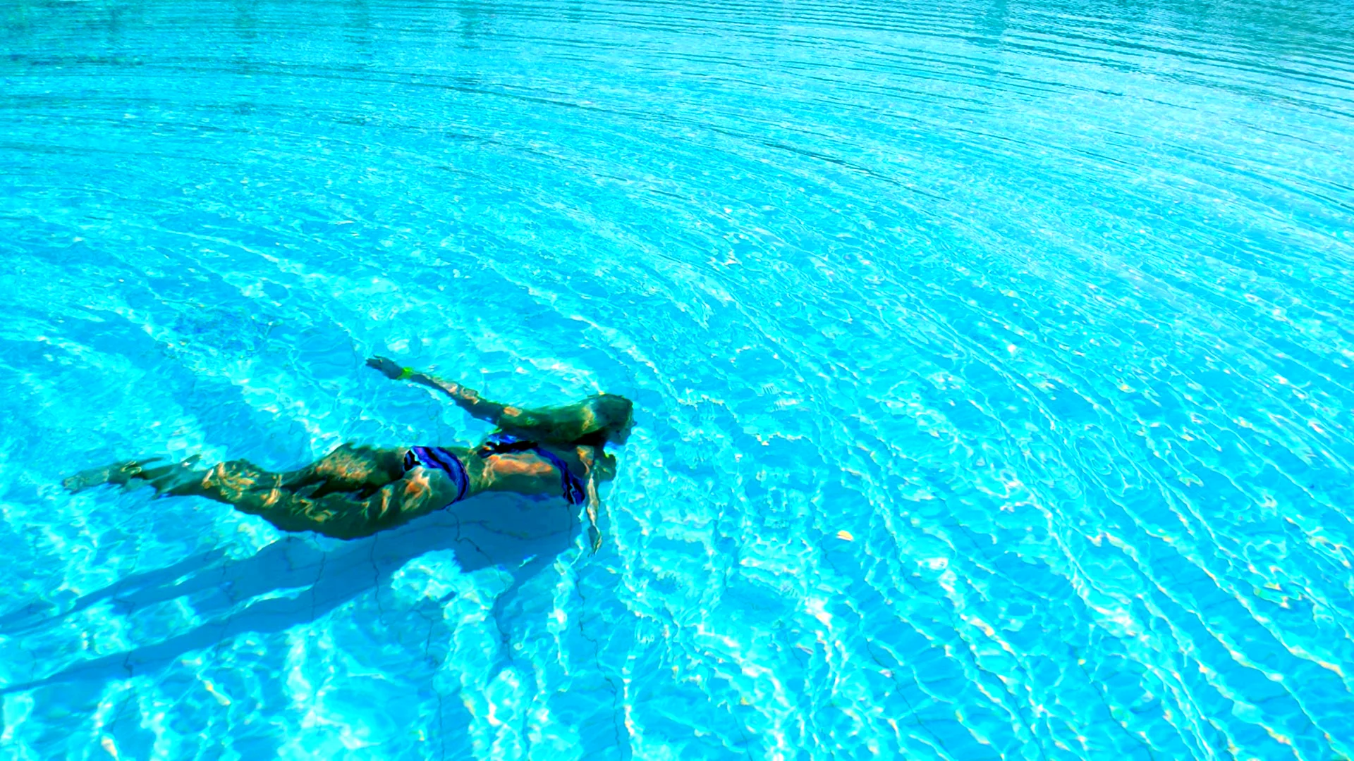 Девушка ныряет в бассейн